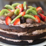 chokolade lagkage med pynt af slik, frugt og bær